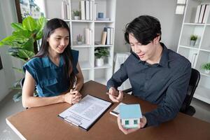 Real Estate Agent Buy Sell Contract Signing with Happy Clients and Agent in Modern Office Environment photo