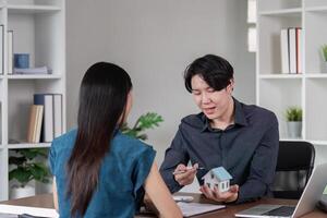 Real Estate Agent Discussing Property Sale Contract with Client in Modern Office Setting photo