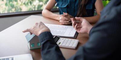Real Estate Agent Discussing Home Purchase Contract with Client at Office Desk photo