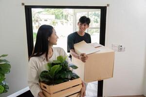 Happy Couple Moving into New House with Boxes and Plants, Starting a New Chapter in Their Lives photo