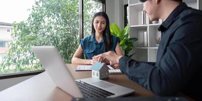 Real Estate Agent and Client Discussing Home Purchase Contract in Modern Office Setting photo
