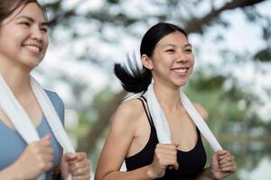 Two Friends Enjoying a Morning Run Together with Towels Around Their Necks in a Park Setting photo