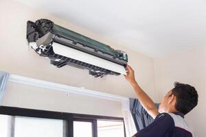 Technician man cleaned mold in the air conditioning system, Repairman washed dirty inside compartments air conditioner, Maintenance and service concepts photo