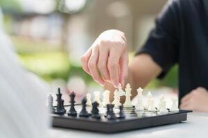 Close-up of a mother playing chess in a park with a son photo