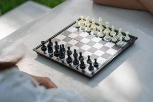 Close up of mother playing chess in a park with a son photo