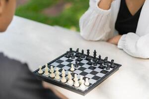 Close-up of a mother playing chess in a park with a son photo