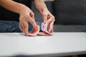 A woman shuffling a deck of playing cards at dining table photo