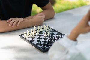 Close-up of a mother playing chess in a park with a son photo