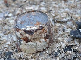 close up rusty can on dirty ash photo