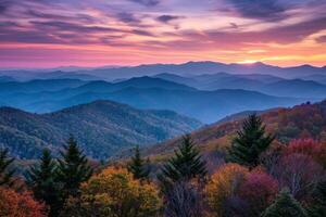 The mountains are covered in trees and the sky is a beautiful mix of orange photo