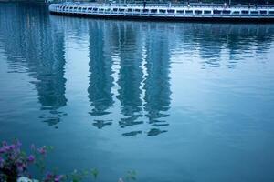 blue pool with waving reflection of building city on water surface photo