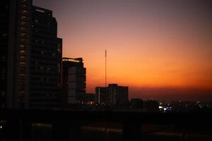 orange blue skyscape background with cloud and silhouette city town building in evening of the day sunset twilight dusk time photo