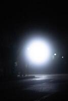 spot light bulb shin in middle of the dark black background with Silhouette House residential area photo