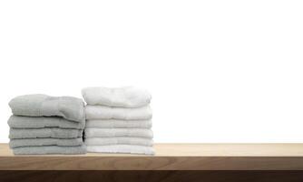 A pile of towels, neatly folded and placed on a wooden table. photo