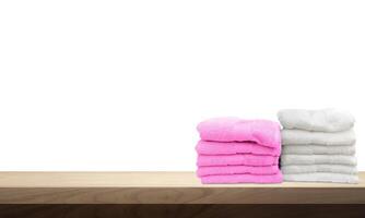 A pile of towels, neatly folded and placed on a wooden table. photo