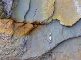 a close up of a rock wall with cracks photo