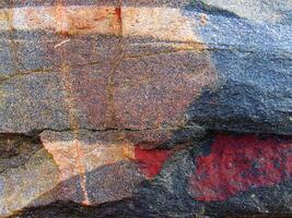 a rock with red and black paint on it photo