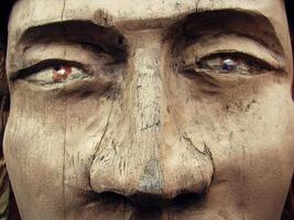 a close up of a wooden statue with a face photo