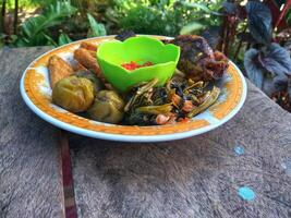 a plate of grilled fish, complete with chili sauce and fresh vegetables photo