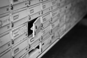 row of white mailboxes with one of them open photo