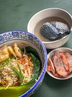 Noodle soup with wonton dumplings and vegetables. separate sauce. Top view photo