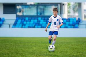 Young soccer player in a white dress dribbling the ball on a soccer match, showcasing agility and skill photo