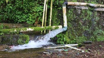 clear mountain spring water flows freely from the pipe photo