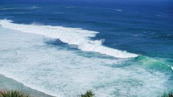 view of rolling waves and ocean from the top front view and surrounded by green plants. The beach is very beautiful. Idea as background, holiday, poster photo