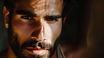 A man with a beard and dark hair is looking at the camera photo