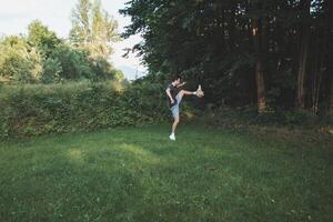 Black-haired athlete plays a friendly football match on the lawn. Amateur sport. Man playing with a ball. Dribbling practice. Sport lifestyle photo