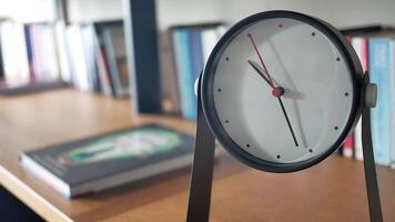 simple modern clock on a book shelf . video