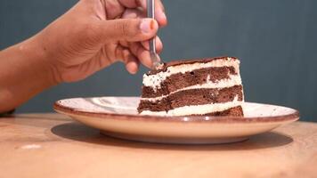 cutting a chocolate and cream cake with a spoon on table video