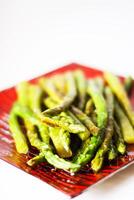 Green grilled asparagus on a red plate photo