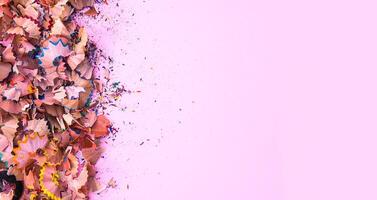 Wooden pencil shavings and colorful crumbs of graphite from sharpener. Top view. photo