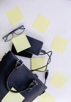 Composition with black bag, external hard disks, colorful paper empty stickers and glasses. photo