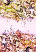 Wooden pencil shavings and colorful crumbs of graphite from sharpener. Top view. photo