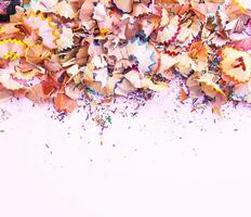 Wooden pencil shavings and colorful crumbs of graphite from sharpener. Top view. photo