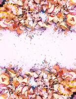 Wooden pencil shavings and colorful crumbs of graphite from sharpener. Top view. photo