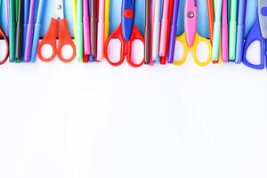 School supplies. Back to School design elements. Colorful markers and scissors on white paper background. photo