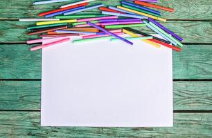 School supplies. Back to School design elements. Colorful markers and white empty paper sheet. photo