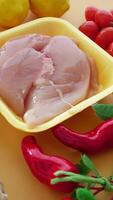 top view of raw breast chicken meat in a plastic packet and vegetables on table video