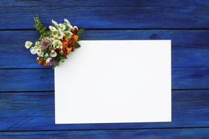 Summer flowers with blank paper for greeting message. Vintage Floral mock up with wild flowers. photo