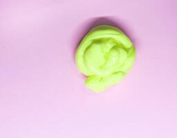 Sample of yellow slime on soft pink background photo