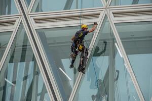 Italy 2024 A rope operator with a harness, lowering himself onto the facade of a building photo