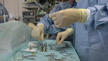 surgeons a man and two women in a large operating room perform microscopic surgery on ENT organs using a surgical microscope and instruments for ENT organs.Innovative technologies in medicine video