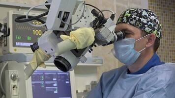 The surgeon is a man in special clothes doing a microscopic operation on the patient's ENT organs using a surgical microscope. Innovative technologies in medicine video