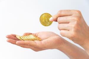 Someone hand holding some pieces of golden Bitcoin token isolated on white background. Bitcoin is one of the popular cryptocurrency, a virtual currency or a digital currency. photo