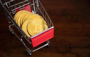 Bitcoin token in a trolley on wooden table. Bitcoin is one of the popular cryptocurrency, a virtual currency or a digital currency. photo