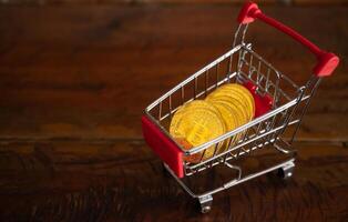 Bitcoin token in a trolley on wooden table. Bitcoin is one of the popular cryptocurrency, a virtual currency or a digital currency. photo