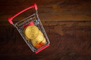 Bitcoin token in a trolley on wooden table. Bitcoin is one of the popular cryptocurrency, a virtual currency or a digital currency. photo